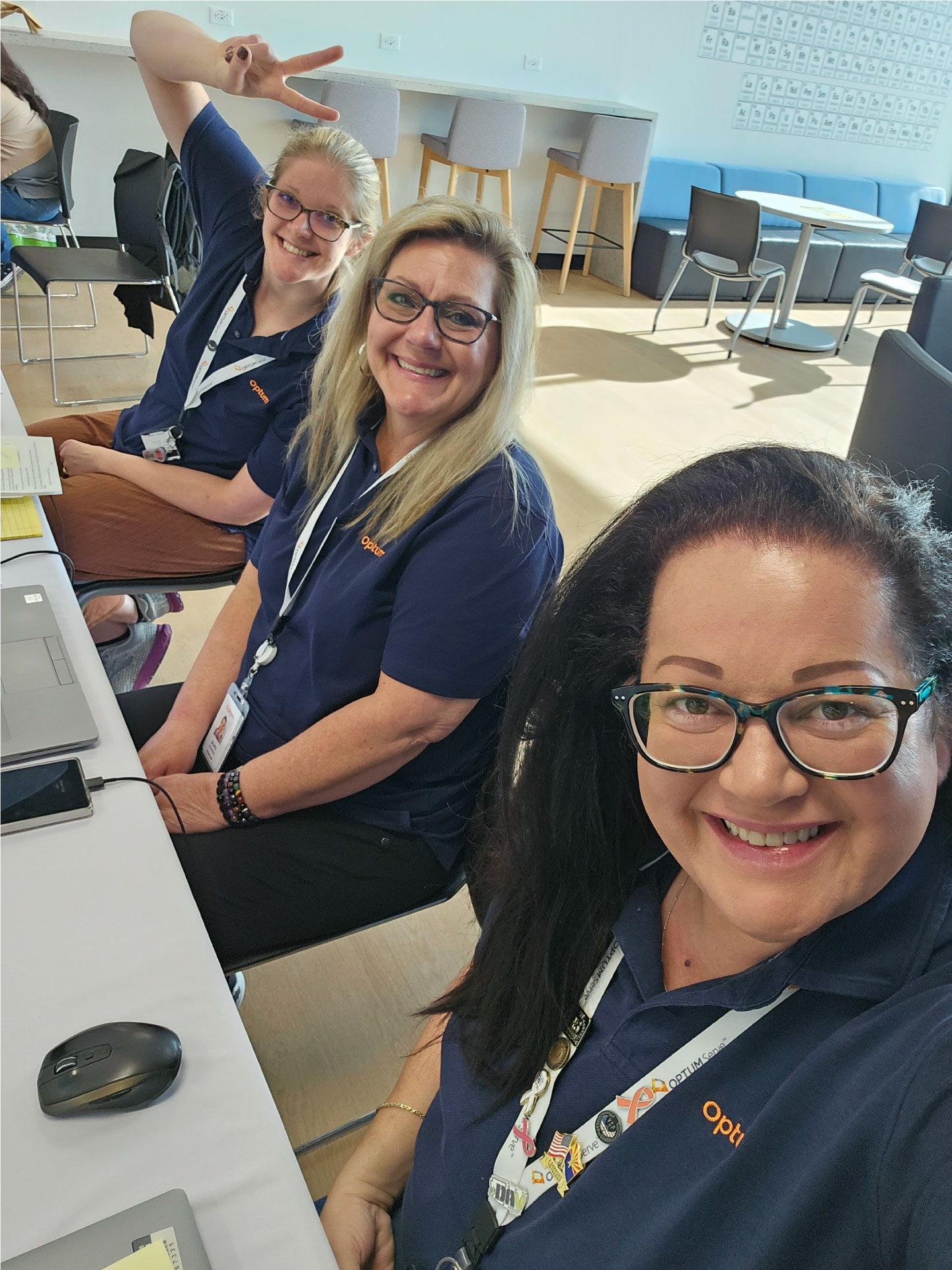Carmen sitting with two coworkers, all are smiling
